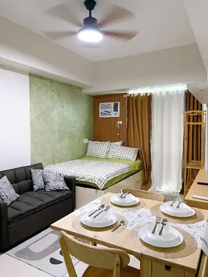 a living room with a table and a couch at Metro Lounge Studio - Cozy Urban Living in Manila
