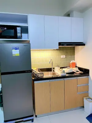 a kitchen with a refrigerator and a sink at Metro Lounge Studio - Cozy Urban Living in Manila
