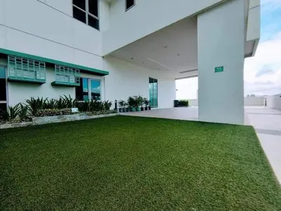an empty courtyard of a building with a green lawn at Metro Lounge Studio - Cozy Urban Living in Manila