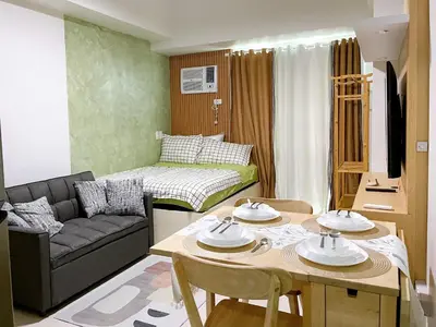 a small living room with a table and a couch at Metro Lounge Studio - Cozy Urban Living in Manila