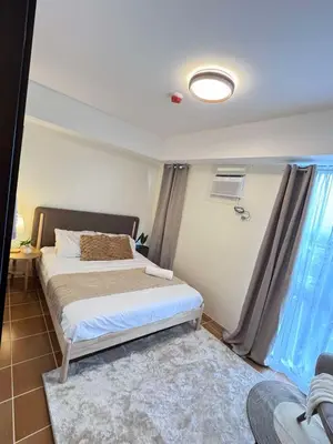 a bedroom with a bed and a window at Queen's Escape in Manila
