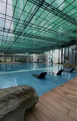 a large building with a pool of water with umbrellas at Queen's Escape in Manila