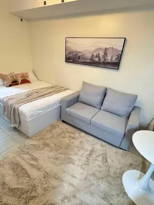 a living room with a bed and a couch at Queen's Escape in Manila