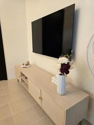 a living room with a flat screen tv on the wall at Queen's Escape in Manila