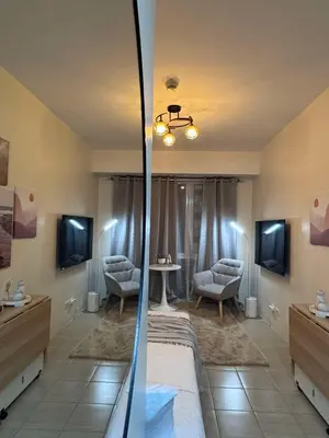 a bedroom with a bed and a table and chairs at Queen's Escape in Manila