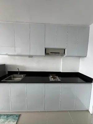 a kitchen with white cabinets and a sink at Sea Residences Condominium in Manila
