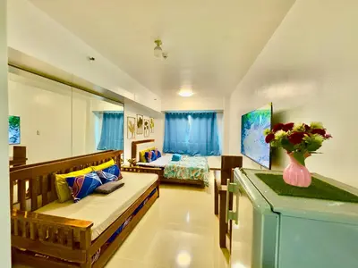 a living room with a couch and a bed at Sea Residences Condominium in Manila
