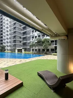 a patio with a chair and a swimming pool at EyaLove's Staycation in Manila