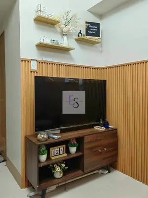 a flat screen tv sitting on top of a wooden entertainment center at EyaLove's Staycation in Manila