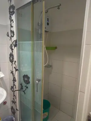 a shower with a glass door in a bathroom at SEA RESIDENCES CONDOTEL by Tvans in Manila