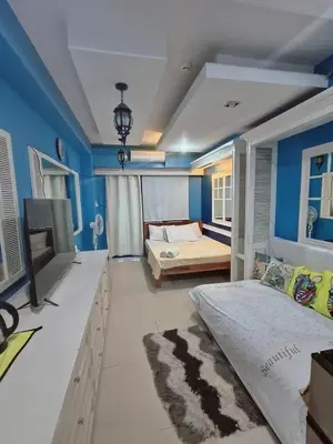 a bedroom with two beds and a tv in it at SEA RESIDENCES CONDOTEL by Tvans in Manila