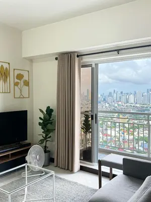 a living room with a view of a city at Corner 37 at Lumiere Residences in Manila