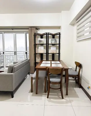 a living room with a table and a couch at Corner 37 at Lumiere Residences in Manila