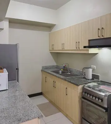an empty kitchen with a sink and a stove at Corner 37 at Lumiere Residences in Manila
