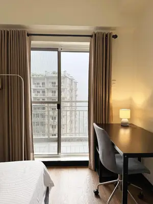 a bedroom with a desk and a bed and a window at Corner 37 at Lumiere Residences in Manila