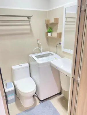 a bathroom with a toilet and a sink at SMDC Coast Residence in Manila