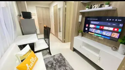 a living room with a large flat screen tv at SMDC Coast Residence in Manila