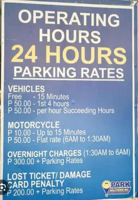 a sign that says operating hours and hours parking rates at Stylish and Cozy Condo Near Mall of Asia in Manila