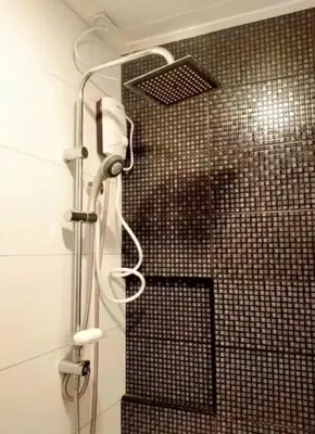 a shower in a bathroom with a tiled wall at Close by landmarks and airport in Manila