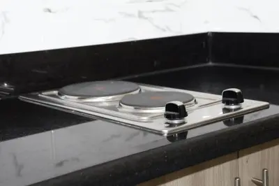 a metal counter top with two stove tops on it at The Nuebe Chalet near SM Moa Pasay City in Manila