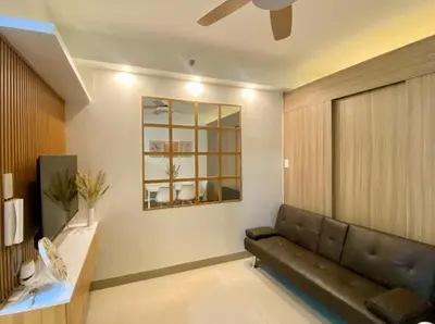a living room with a couch and a window at The Nuebe Chalet near SM Moa Pasay City in Manila