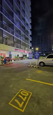 a parking lot with a car parked in front of a building at Bellas Place Shell Residences MOA in Manila