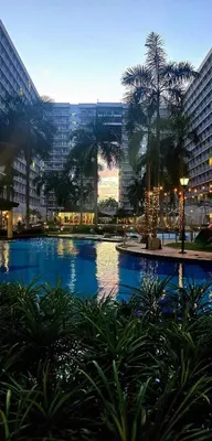 a large swimming pool in a city with tall buildings at Bellas Place Shell Residences MOA in Manila