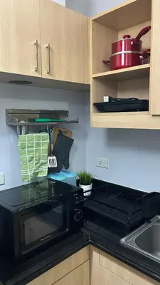 a kitchen with a black microwave and a sink at Condo Unit at La Verti Residences in Manila