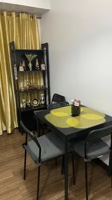 a black table with chairs and a shelf with dishes at Condo Unit at La Verti Residences in Manila