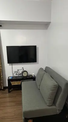 a living room with a couch and a flat screen tv at Condo Unit at La Verti Residences in Manila