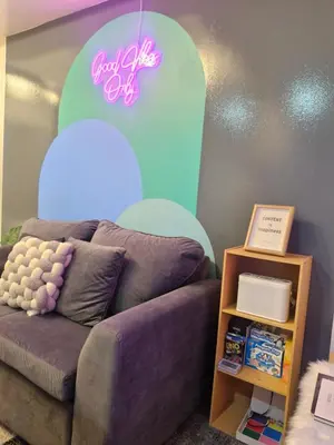 a room with a couch and a pink sign on the wall at 2BR Unit Azure Urban Resort Residences in Manila