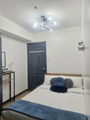 a bedroom with a bed with a black door at 2BR Unit Azure Urban Resort Residences in Manila
