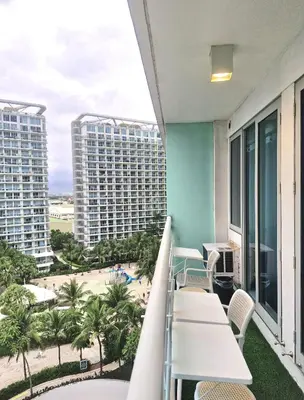 a balcony with a view of the beach and buildings at 2BR Unit Azure Urban Resort Residences in Manila