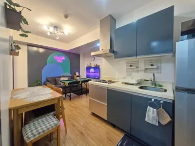 a kitchen with blue cabinets and a dining room at 2BR Unit Azure Urban Resort Residences in Manila