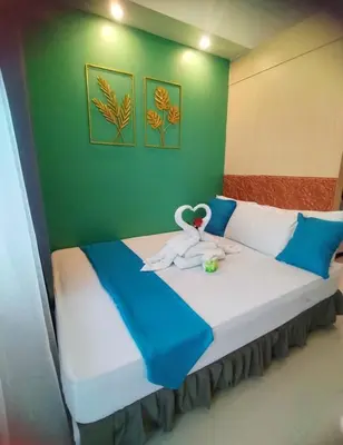 a bedroom with a bed with two swans on it at Comfystay at Sea Residences tower C in Manila