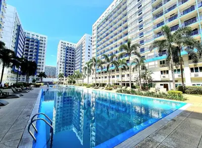 a large swimming pool in front of a large building at Comfystay at Sea Residences tower C in Manila