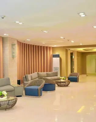 a lobby with couches and tables in a building at Comfystay at Sea Residences tower C in Manila