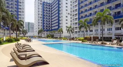 a large swimming pool in a city with tall buildings at Comfystay at Sea Residences tower C in Manila