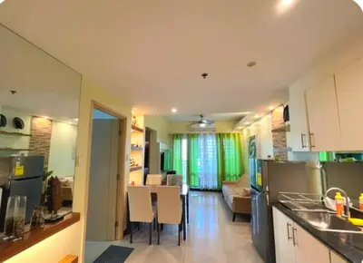 a kitchen and living room with a table and chairs at Comfystay at Sea residences 2 bedrooms in Manila
