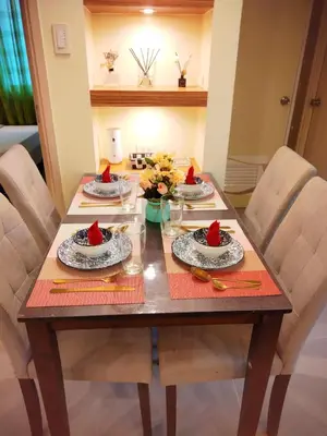 a wooden table with four plates of food on it at Comfystay at Sea residences 2 bedrooms in Manila