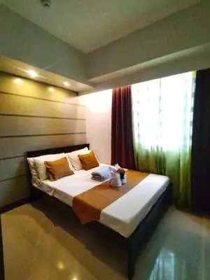 a bedroom with a large bed with a window at Comfystay at Sea residences 2 bedrooms in Manila