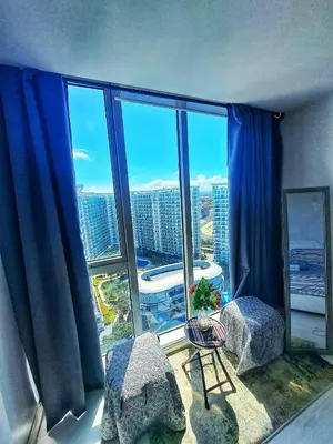 a room with a large window with blue curtains at 2bedroom azure beachview 7 in Manila