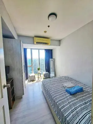 a bedroom with a bed and a large window at 2bedroom azure beachview 7 in Manila