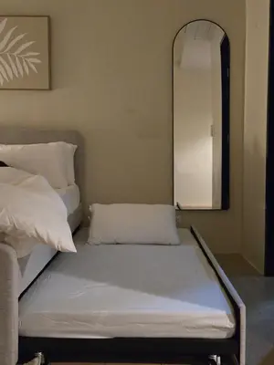 a bed in a room with a mirror at ScandiCozy Studio NAIA T3 Newport Wifi Pool Netflx in Manila