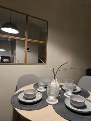 a table with plates and glasses on top of it at ScandiCozy Studio NAIA T3 Newport Wifi Pool Netflx in Manila