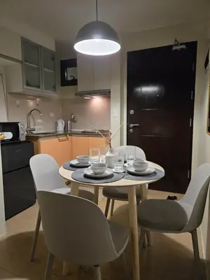 a kitchen with a table with chairs and a dining room at ScandiCozy Studio NAIA T3 Newport Wifi Pool Netflx in Manila