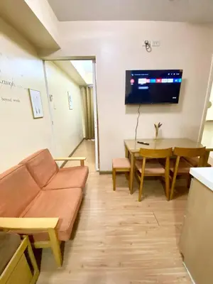 a living room with a couch and a table and a tv at 2 bedroom azure cityview 1 in Manila