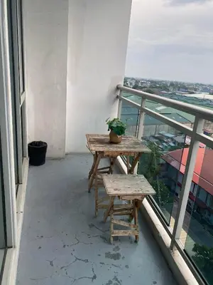 a table and bench on the balcony of a building at 2 bedroom azure cityview 1 in Manila