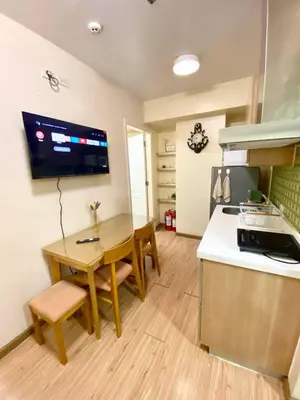 a kitchen with a wooden table and a kitchen with a stove at 2 bedroom azure cityview 1 in Manila