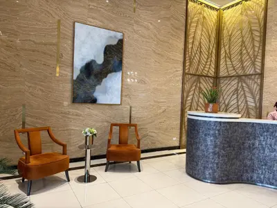a lobby with two chairs and a counter with at Apartment in Salcedo village, Makati City in Manila